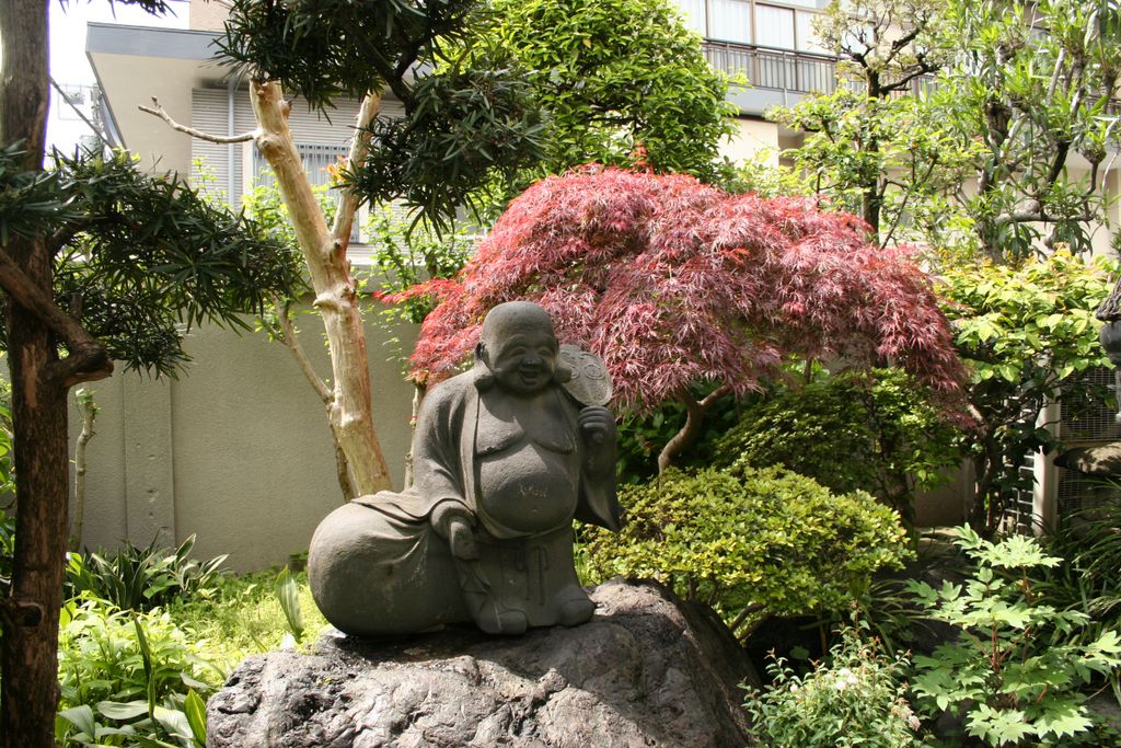 Small Buddha in a courtyard, hidden in a small house in Asakusa